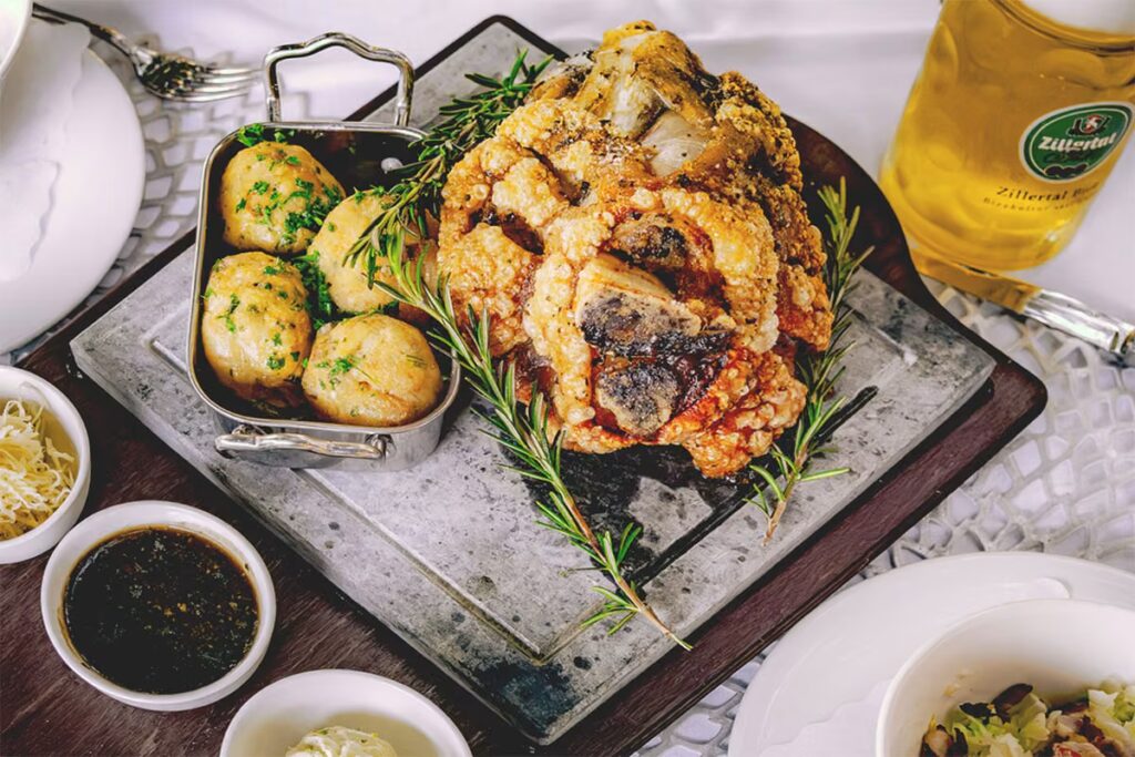 Foodfotografie die Appetit macht - Foodfotografie einer knusprigen Schweinshaxe mit klassischen Beilagen